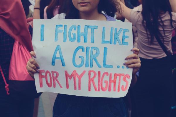 Young woman holds sign at protest which reads: I fight like a gir lfor my rights