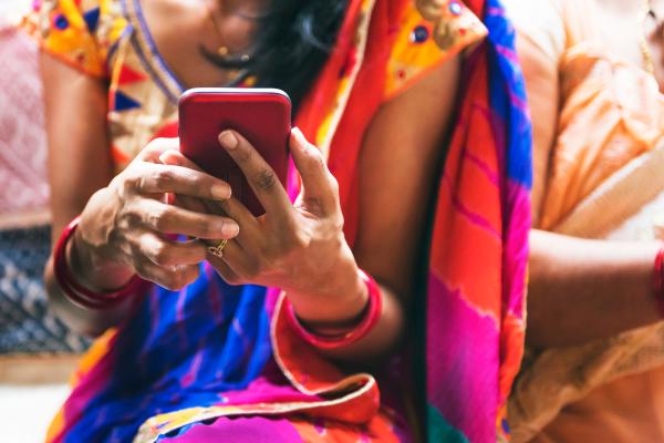 Woman dressed in sari uses mobile phone