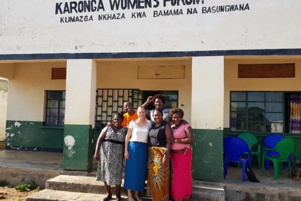 Photo of our Malawi team standing arm in arm, outside of the Karonga Women’s Forum