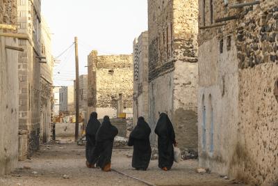 Women walking through Yemeni village, carrying their shopping