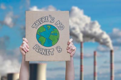 Hands hold up poster which reads 'There is no Planet B'